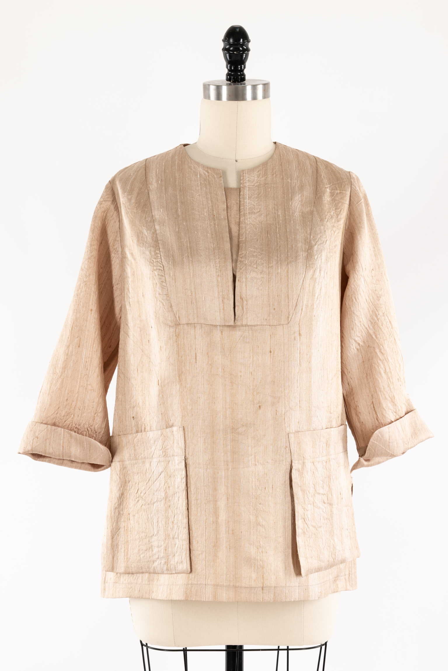 Beige textured tunic with 3/4 sleeves and front pockets, displayed on mannequin for sewing projects