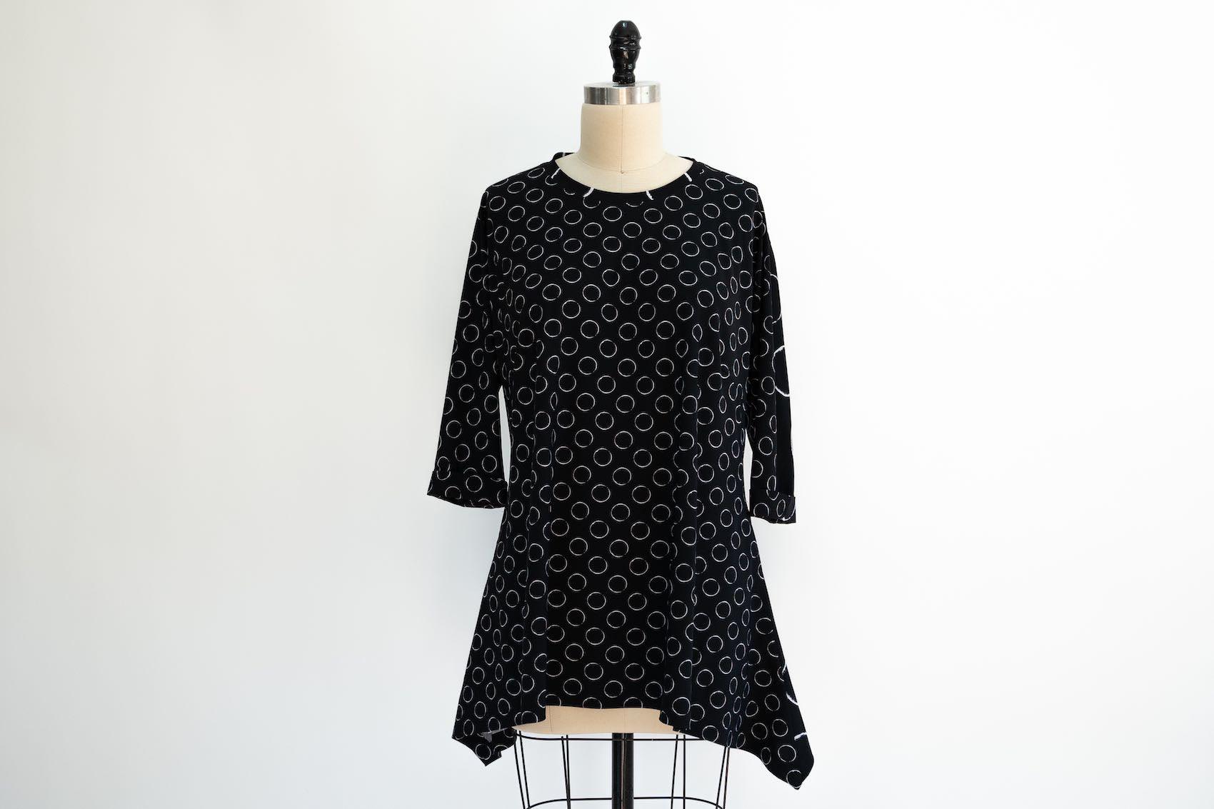 Black dress with white circle print on mannequin, ideal for sewing apparel or fashion projects