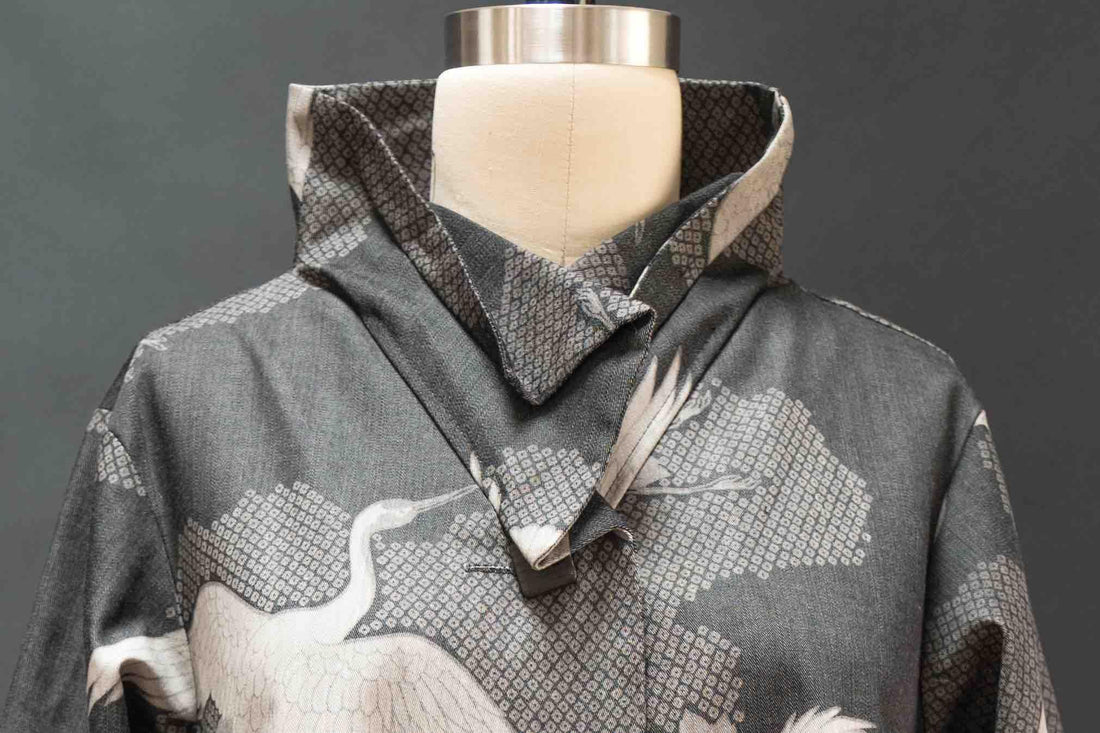 Gray fabric with white crane print and geometric pattern, styled on mannequin for apparel sewing