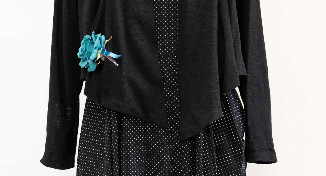 Black polka dot dress with solid black overlay and teal fabric flower accent, ideal for sewing projects
