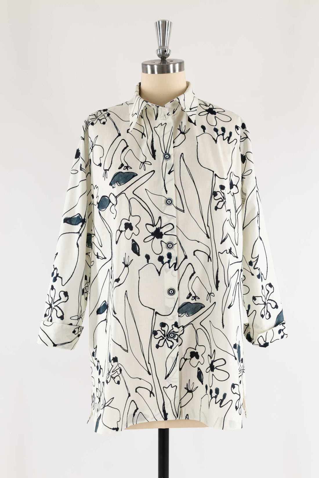 Cream shirt with black and blue floral print, button-front, long sleeves, displayed on mannequin