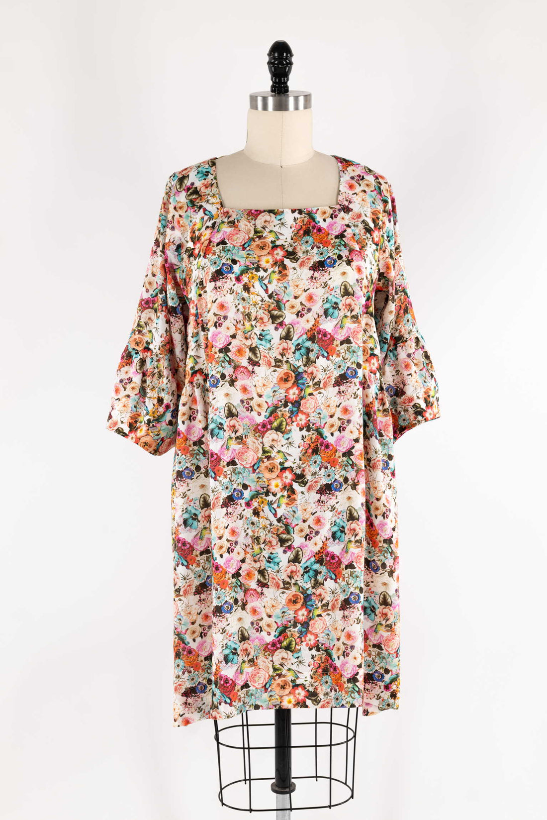 Floral print dress with bell sleeves on mannequin, ideal for sewing projects