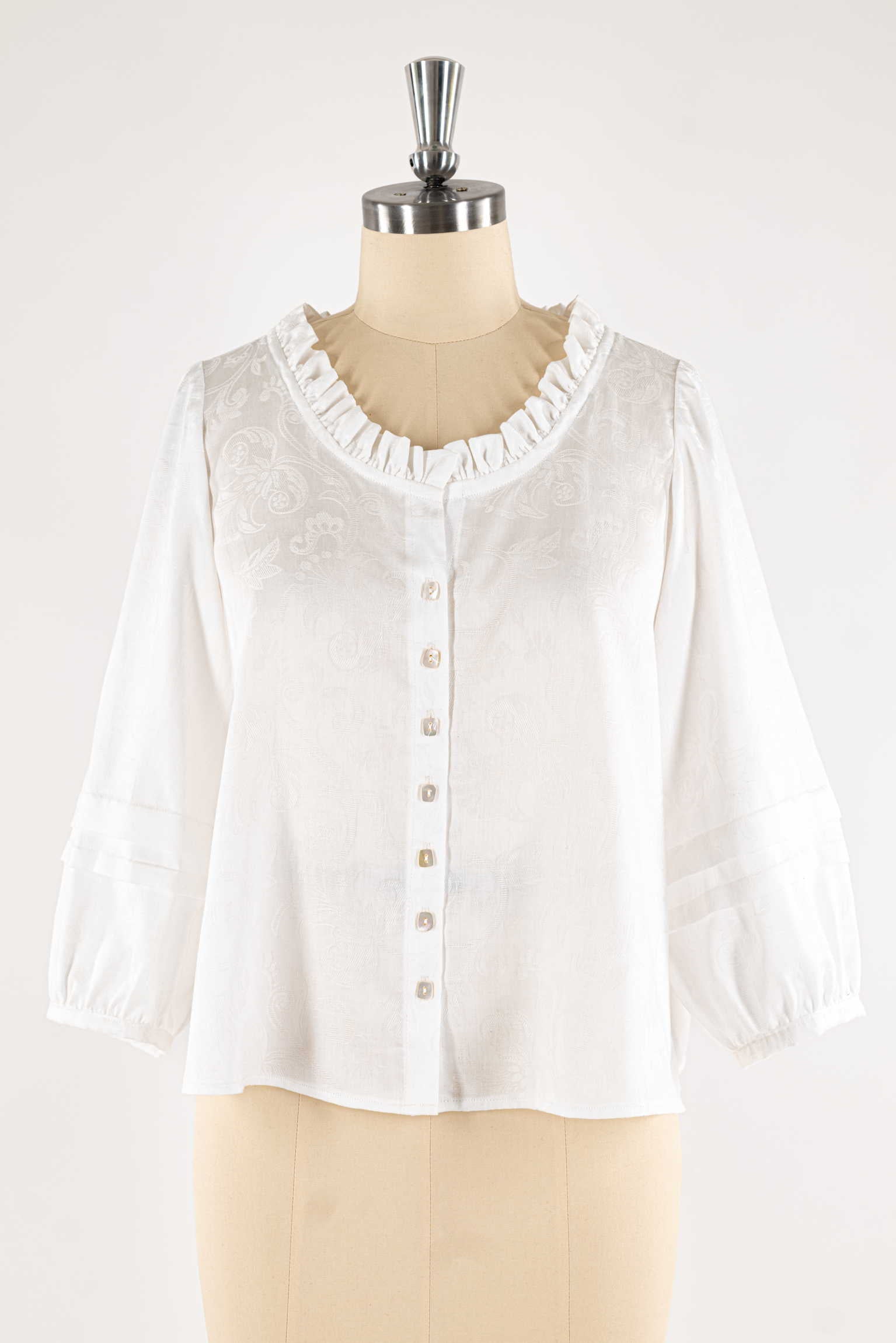White floral jacquard blouse with ruffled neckline and button front, ideal for sewing apparel projects
