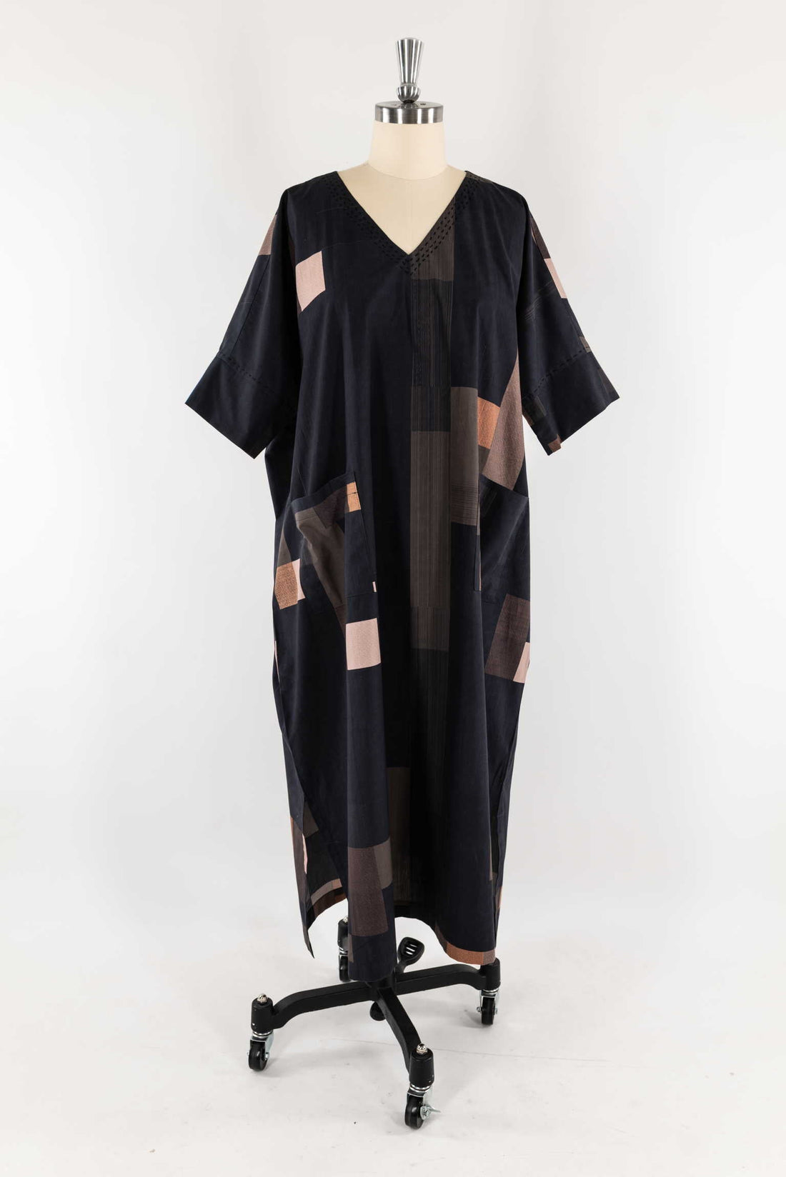 Black geometric patchwork kaftan dress with V-neck, displayed on mannequin for sewing and fashion design