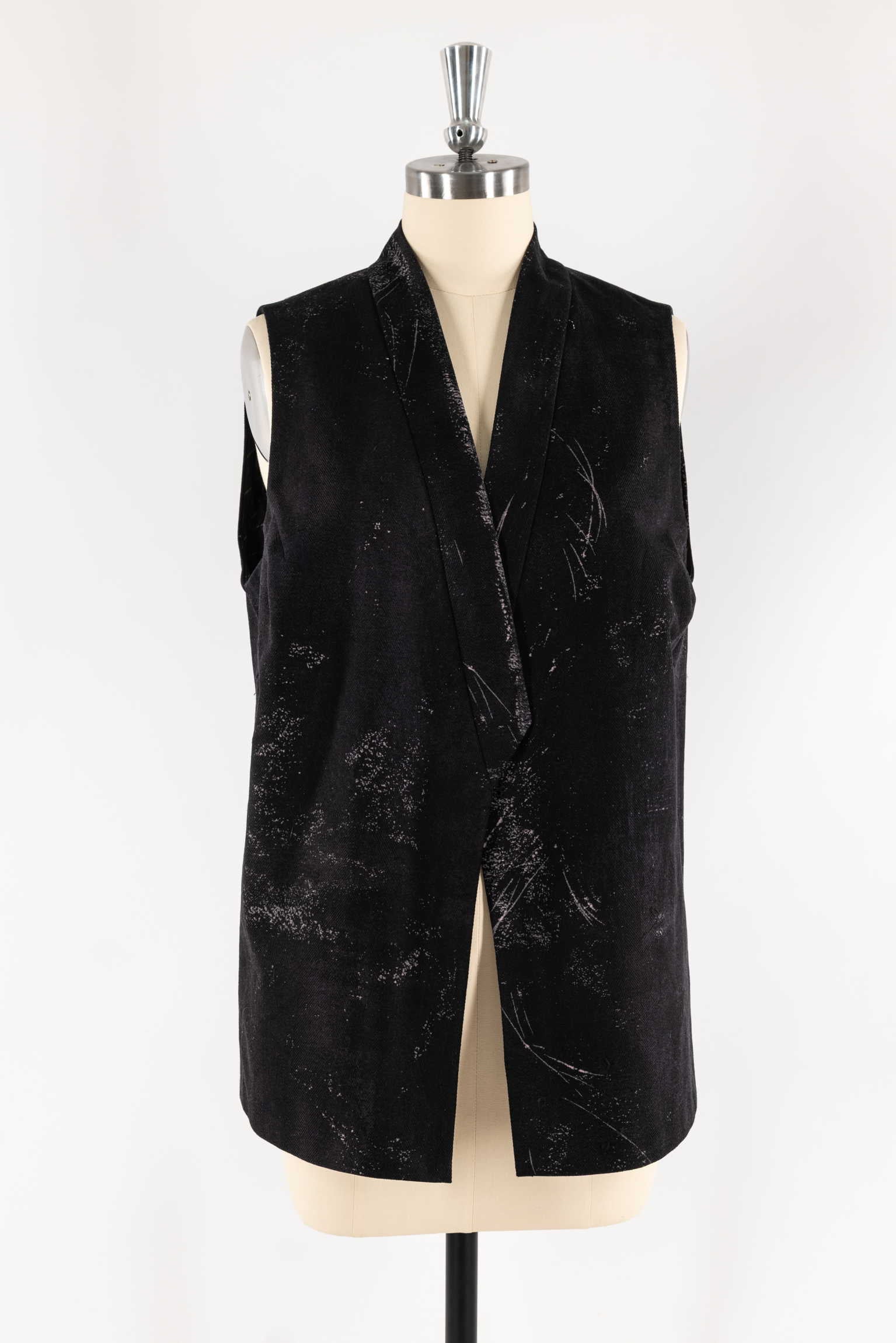 Black textured sleeveless vest with abstract white speckles on mannequin