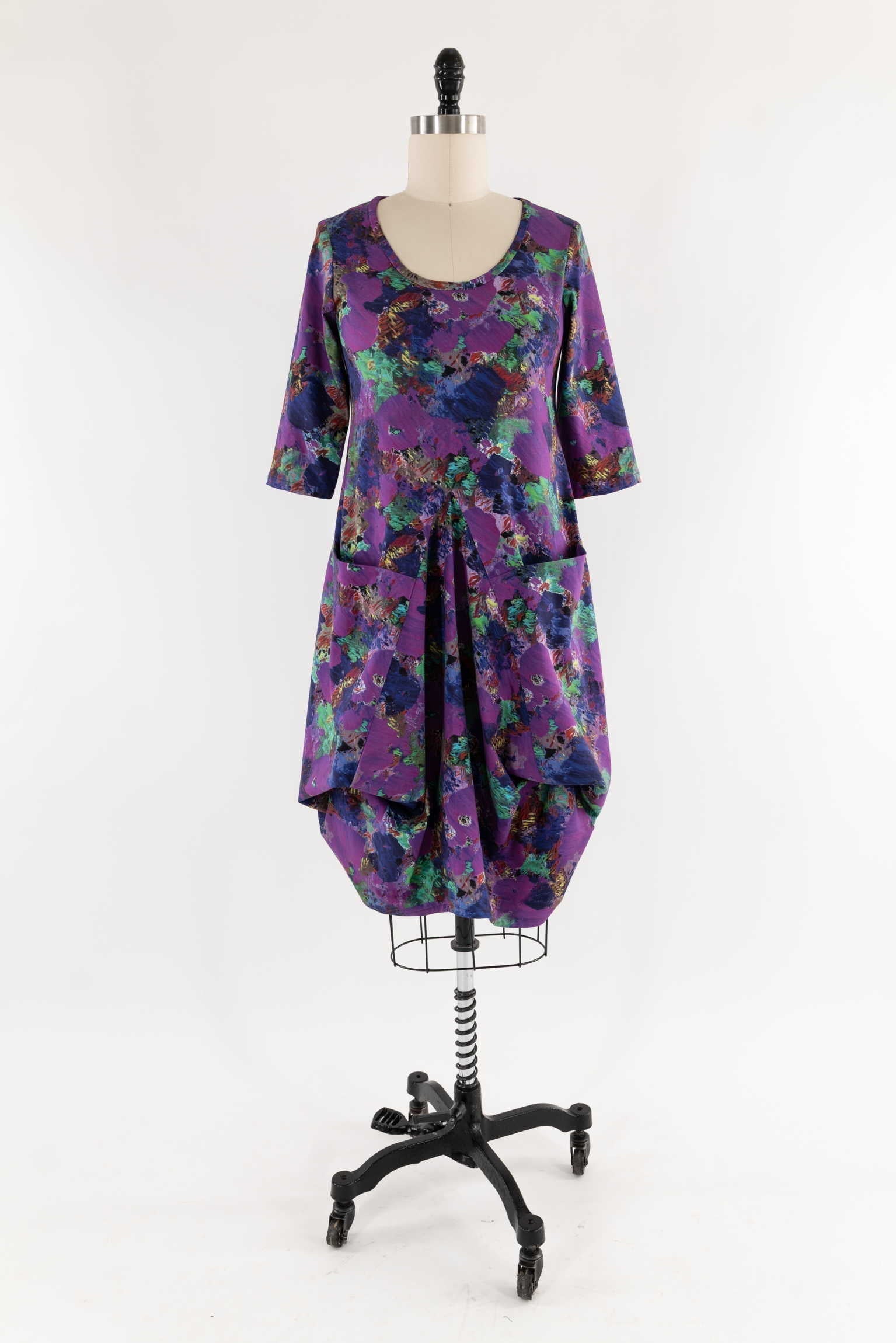 Purple abstract print dress with 3/4 sleeves and front pockets on mannequin