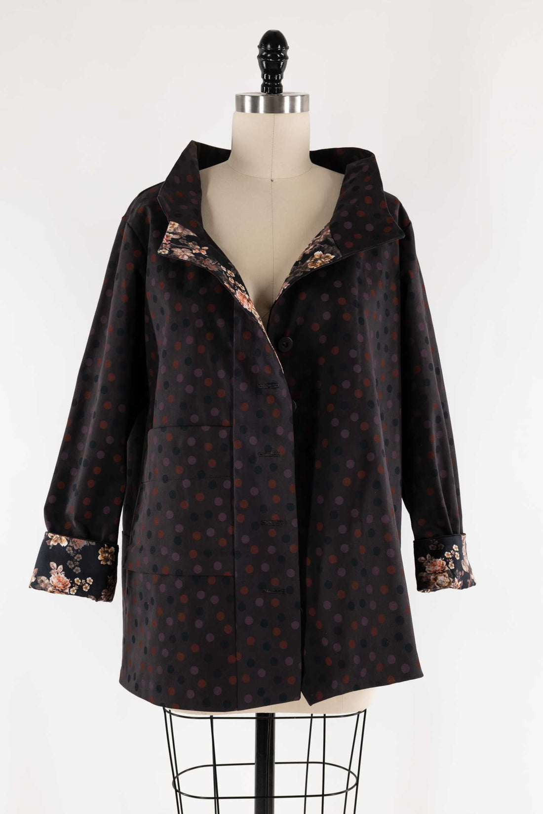 Polka dot coat with floral lining on mannequin, ideal for sewing apparel and fashion projects