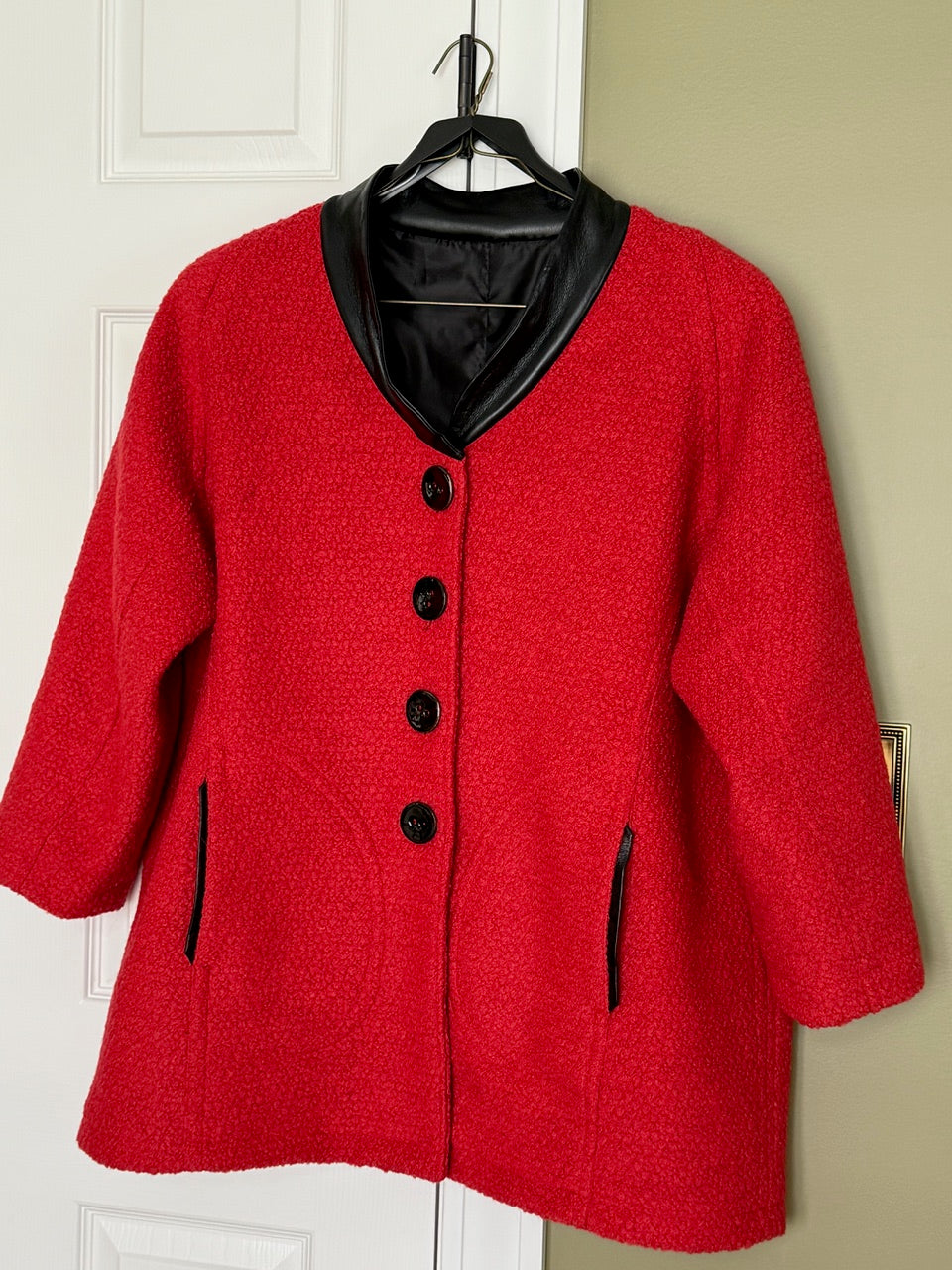 Red textured wool coat with black leather trim and buttons, perfect for fashion sewing projects