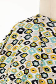 Geometric ikat print fabric in teal, yellow, black, and cream — ideal for apparel and quilting projects
